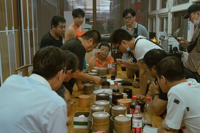 Men crowd over a cricket fight in Beijing in September. Competitive cricket fights are believed to have been held for more than 1,000 years in China.