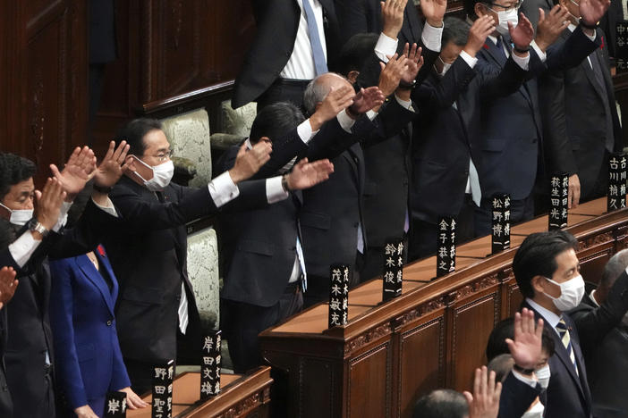 Japanese Prime Minister Fumio Kishida, forth from left, and other lawmakers give three cheers after dissolving the lower house, the more powerful of the two parliamentary chambers, during an extraordinary Diet session at the lower house of parliament Thursday.