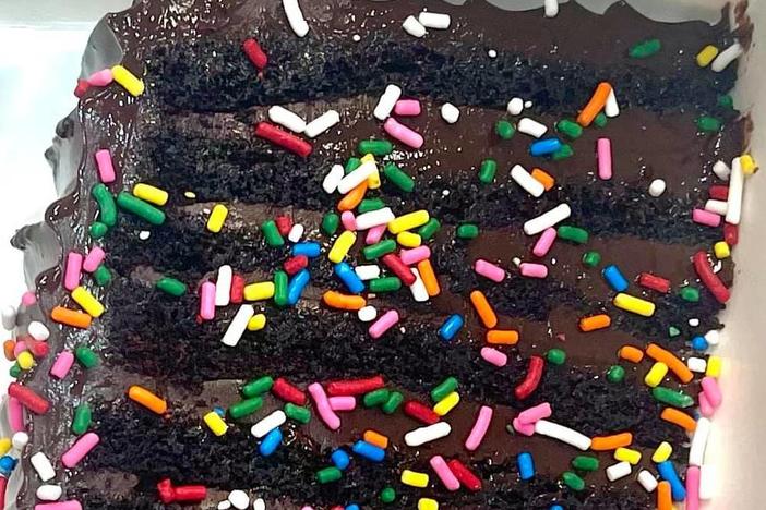 A slice of the 12-layer chocolate cake known as "Bruce" is adorned with colorful sprinkles at the British bakery Get Baked. But regulators say the topping is illegal, as it includes a color additive that is permitted only for other uses.