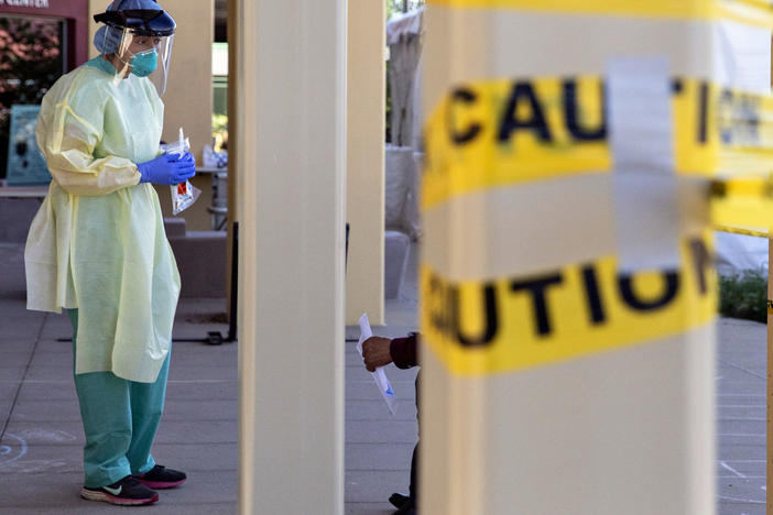A doctor stands at a walk-up coronavirus testing site at West County Health Center in San Pablo, Calif., in April 2020. Pandemic burnout has affected thousands of health care workers.