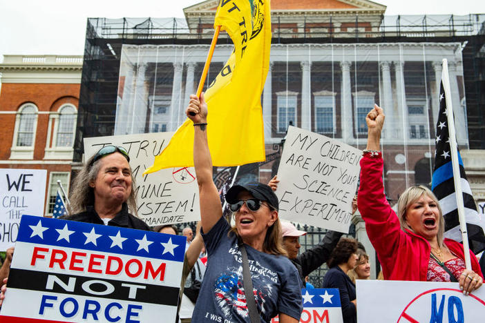 Demonstrators gather outside the Massachusetts State House in Boston to protest COVID-19 vaccination and mask mandates. The political divide on the issue is only deepening, as Republican leaders of other states take more steps to thwart mandates.