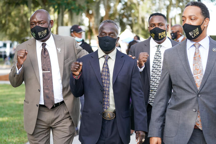 Attorney Ben Crump, left, and Marcus Arbery Sr., the father of Ahmaud Arbery, second from left, arrive at the Glynn County Courthouse in Brunswick, Ga., as jury selection begins for the trial of the shooting death of Ahmaud Arbery on Monday.