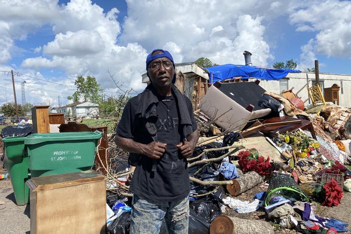 Donald Caesar, Jr., 49, stands in front of a pile of garbage. That's what's left of his family's home a month after Hurricane Ida ripped through LaPlace, La.