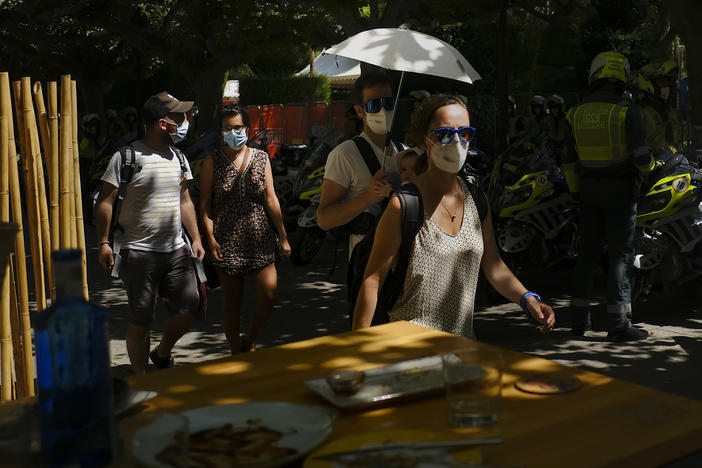 A man shelters a baby from the sun with an umbrella during a heatwave in Burgos, northern Spain, Saturday, Aug. 14, 2021. Cities in Europe saw recording-setting heat this summer, with some regions reaching 117.3°F.