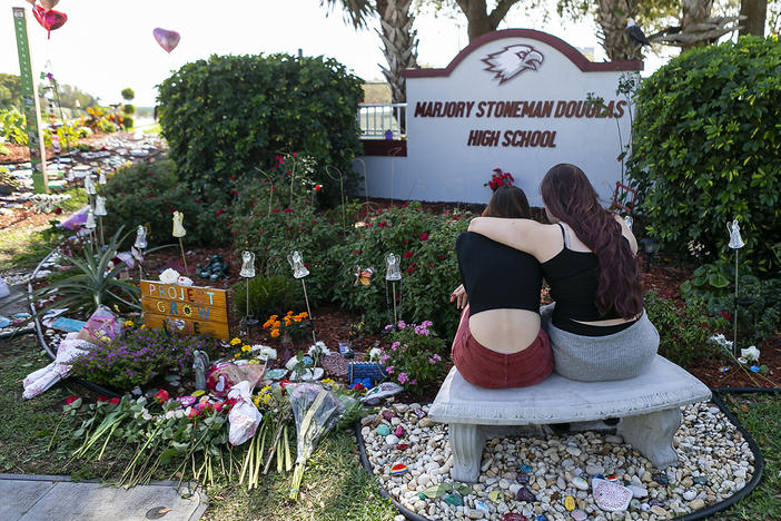 Mourners visit a makeshift memorial outside Marjory Stoneman Douglas High School in Parkland, Fla., on Feb. 14, 2020, during the two-year anniversary of the Parkland shooting that killed 17 people and injured another 17.