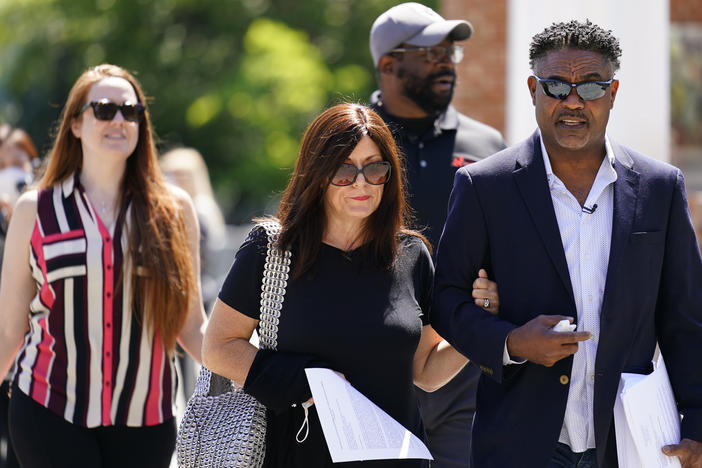 Former NFL players Ken Jenkins (right) and Clarence Vaughn III (center right), along with their wives, Amy Lewis (center) and Brooke Vaughn (left), carry petitions demanding equal treatment for everyone involved in the settlement of concussion claims against the NFL, to the federal courthouse in Philadelphia in May.