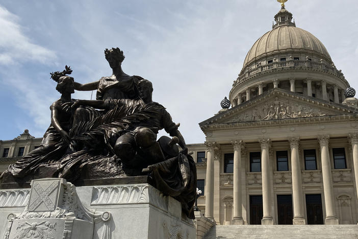A monument to the women of the Confederacy stands in front of the Mississippi State Capitol.