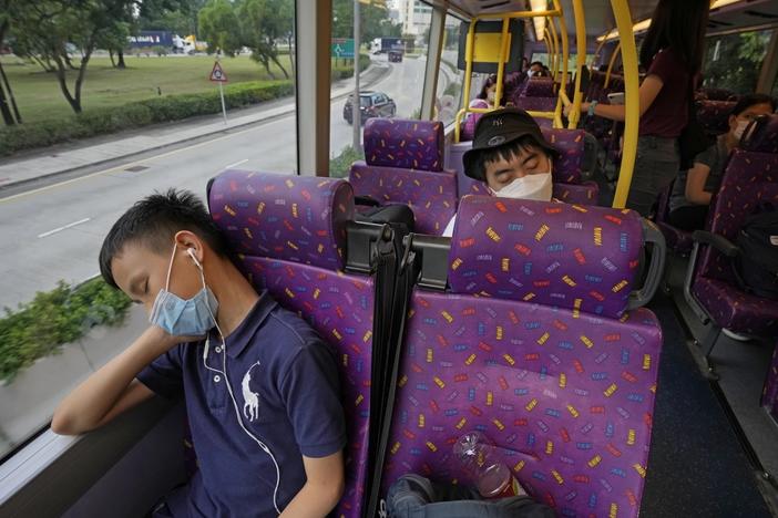 Passengers sleep on the upper deck of a double-decker bus in Hong Kong on Saturday.