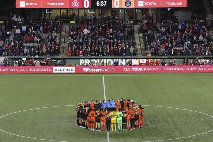 Portland Thorns and Houston Dash players, along with referees, gather at midfield, in demonstration of solidarity with two former NWSL players who came forward with allegations of sexual harassment and misconduct against a prominent coach, during an NWSL soccer match in Portland, Ore., Oct. 6, 2021.