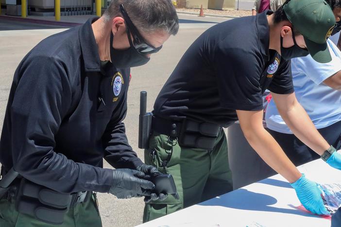 Officials help process and log personal items from migrants entering the Central Processing Center in El Paso, Texas, in this May 4 photo provided by the U.S. Border Patrol.