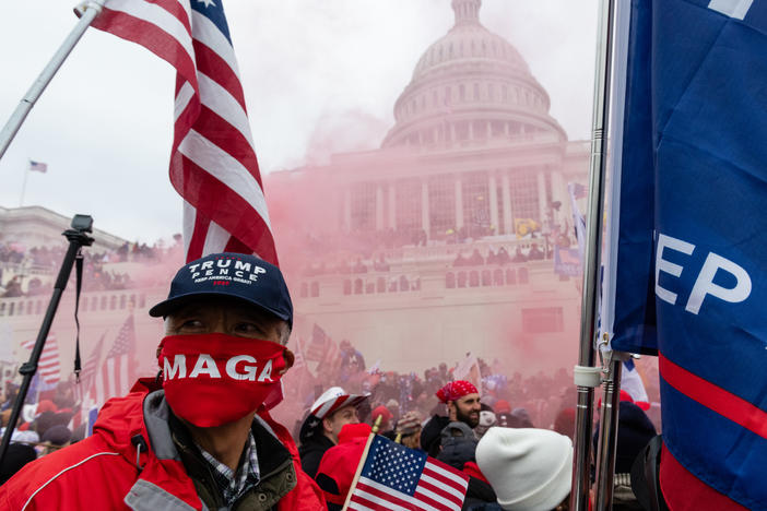 A protester unleashes a smoke grenade in front of the U.S. Capitol building on Jan. 6.