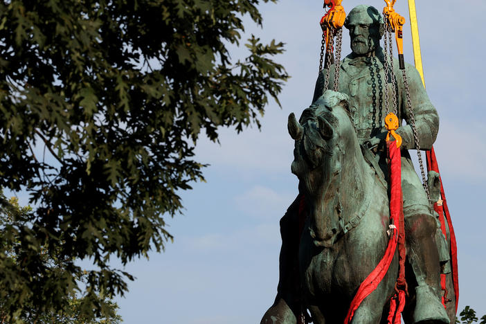 Workers remove a statue of Confederate Gen. Robert E. Lee from Market Street Park in Charlottesville, Va., in July. Initial plans to remove the statue four years ago sparked the infamous "Unite the Right" rally at which 32-year-old Heather Heyer was killed.