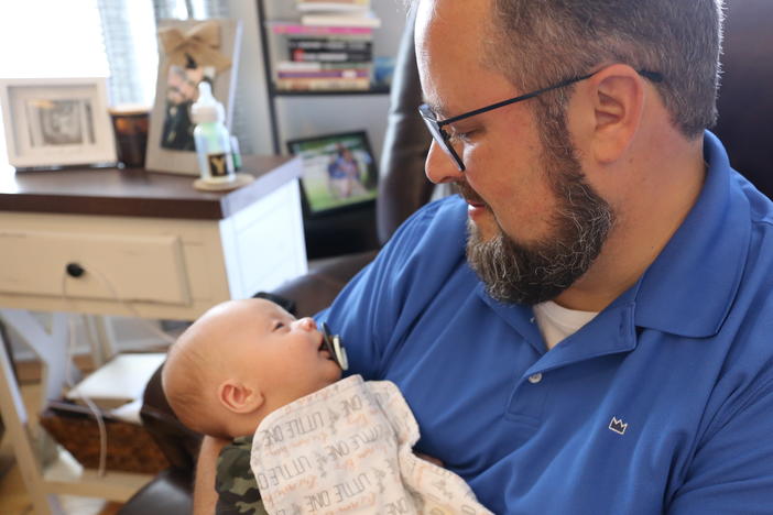 Scott Baisley holds his son Sullivan, who was delivered shortly before his mother died of COVID-19.