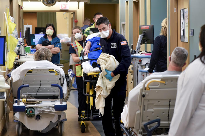 An ambulance crew weaves a gurney through the halls of Sparrow Hospital's emergency department in Lansing, Michigan. Overcrowding has forced the staff to triage patients, putting some in the waiting rooms and treating others on stretchers and chairs in the halls.