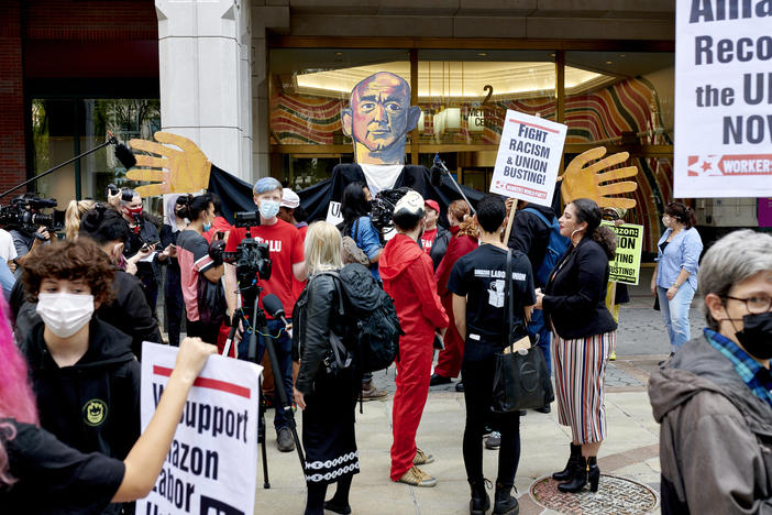 Workers and supporters hold signs after filing a petition requesting an election to form a union outside the National Labor Relations Board (NLRB) regional office in the Brooklyn Borough of New York, U.S., on Monday, Oct. 25, 2021. Amazon.com Inc. workers hoping to unionize four company facilities in Staten Island formally filed a petition with federal labor officials to hold a union election.