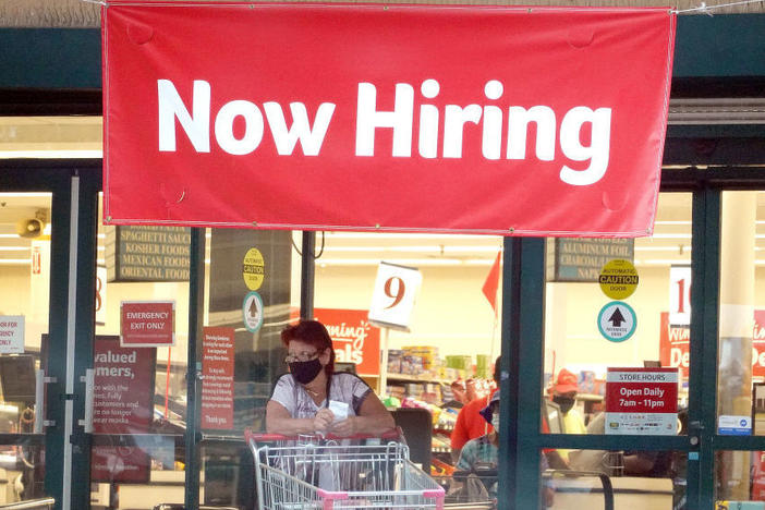 A "Now Hiring" sign hangs at the entrance to a Winn-Dixie supermarket in Hallandale Beach, Fla.