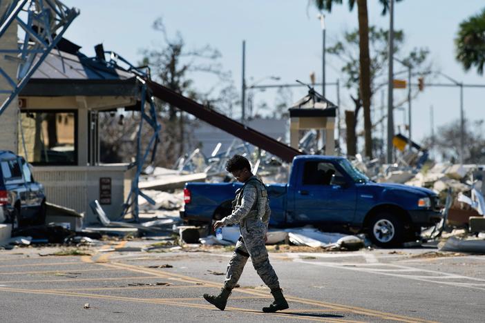 A military police officer walks near a destroyed gate in Tyndall Air Force Base in Florida in the aftermath of Hurricane Michael on Oct. 12, 2018. The Pentagon says climate change is a national security concern.
