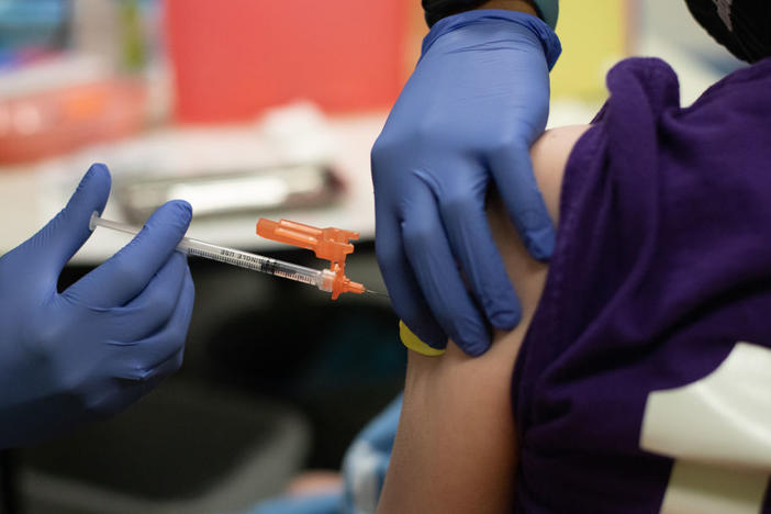 A health care worker administers a dose of the Pfizer-BioNTech COVID-19 vaccine to a child at a pediatrician's office in Bingham Farms, Michigan. Federal agencies are considering whether to start giving the vaccine to children ages 5 to 11 in the near future.