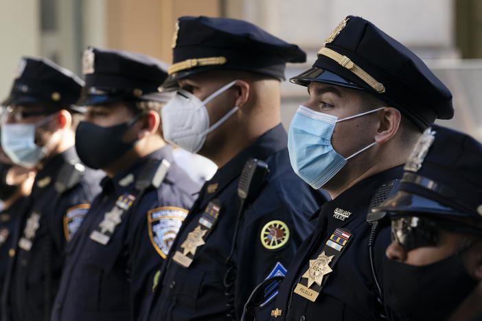 New York Police Department officers in masks stand during a service at St. Patrick's Cathedral in New York, last October.