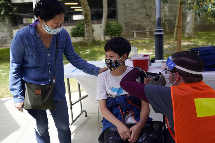 Colin Sweeney, 12, got a shot of the Pfizer COVID-19 vaccine as his mother, Nicole, stands by in Pasadena, Calif., in May. As of this week, kids aged 5 to 11 can also get vaccinated against COVID-19.