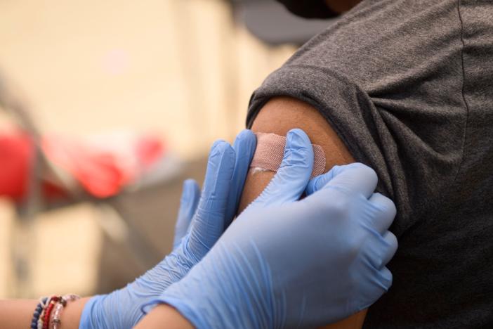 A person receives a bandage after their first dose of the Pfizer COVID-19 vaccine at a mobile vaccination clinic during a back to school event in August. Vaccines could be available for kids ages 5 to 11 as early as next week.