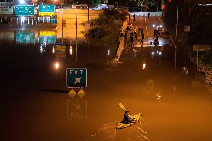 A kayaker paddles down an interstate in Pennsylvania after flooding from Hurricane Ida earlier this year. Several dozen people died, some in cars and basement apartments, during extreme flash flooding.