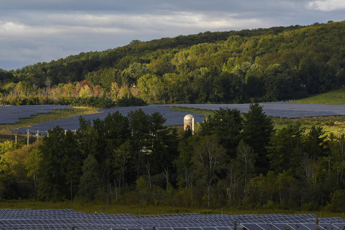 Solar farms surround trees at Cornell University in Ithaca, N.Y. The city voted Wednesday night to decarbonize the city's buildings and install more energy efficient appliances and more solar panels. The city says the move will cut 40% of their carbon emissions.