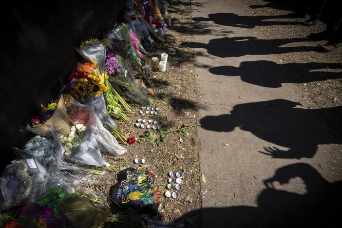 Visitors cast shadows at a memorial to the victims of the Astroworld concert in Houston on Sunday, Nov. 7, 2021.