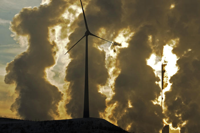 A wind turbine in front of a steaming coal power plant in Gelsenkirchen, Germany in 2010. New reports find countries' latest promises to cut climate emissions are still not enough to avoid the worst impacts from warming.