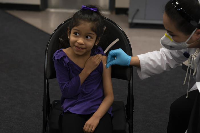 Elsa Estrada, 6, smiles at her mother before receiving the Pfizer-BioNTech COVID-19 vaccine on Tuesday at a pediatric vaccine clinic for children at Willard Intermediate School in Santa Ana, Calif.
