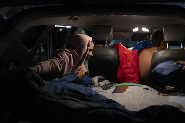 Veronica Vargas helps her children get ready for bed. The three boys sleep in the back of the SUV while Vargas and her partner, Alex, work the overnight shift.