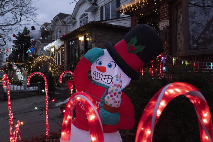 An inflatable snowman and candy canes are part of the decorations that adorn houses in Brooklyn's Dyker Heights neighborhood on Dec. 22, 2020 in New York. A shopping surge by households this year has snarled up global supply chains, and now the race is on to get products on shelves in time for Christmas.