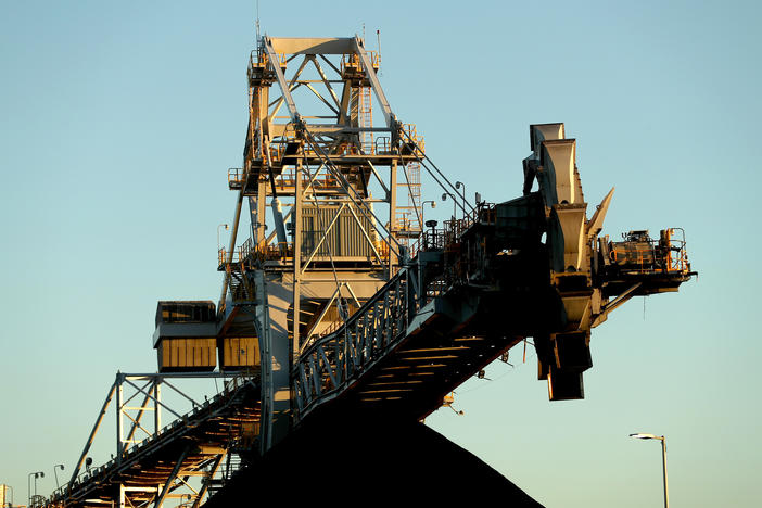 A stacker-reclaimer next to a stockpile of coal at the Newcastle Coal Terminal in Newcastle, New South Wales. Australia is a major coal producer. A new draft agreement at the climate summit in Scotland calls for ending coal power.