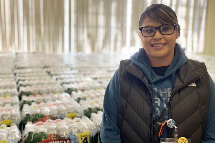 Dot Thurby with some of the thousands of water bottles the Confederated Tribes of Warm Springs distributes to members every day.