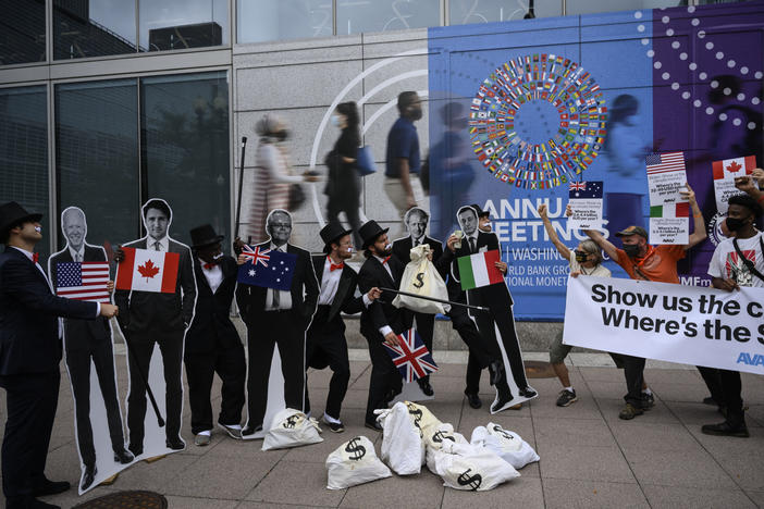 Activists dressed as debt collectors hold cutouts of the leaders of the United States, Canada, Australia, the UK and Italy in front of the International Monetary Fund headquarters in Washington, D.C., last month to ask rich nations to keep their financial commitment to developing countries to tackle climate change.
