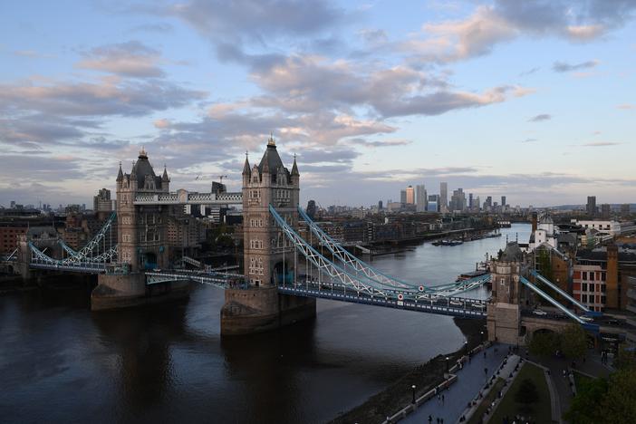 Tower Bridge over The River Thames and, in the distance, the secondary central business district of Canary Wharf are pictured as the sun sets in London.