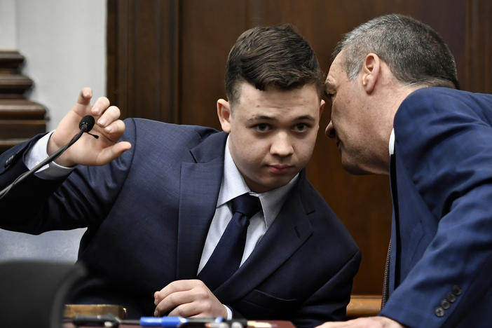 Kyle Rittenhouse (left) listens to his attorney Mark Richards as he takes the stand during his trial on Wednesday in Kenosha, Wis.