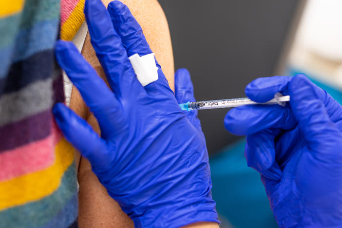 A vaccination center worker inoculates a woman with the Biontech vaccine against Covid-19 in Lower Saxony.