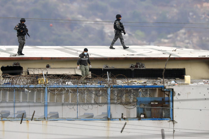Police walk on the roof of the Litoral Penitentiary on Saturday after riots broke out inside the jail in Guayaquil, Ecuador.