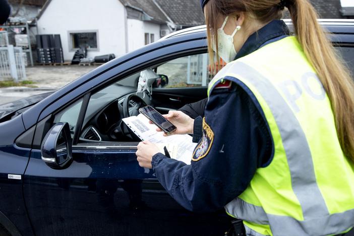 An Austrian police officer checks a driver's vaccination certificate during a traffic control stop in Graz, Austria, on Monday.