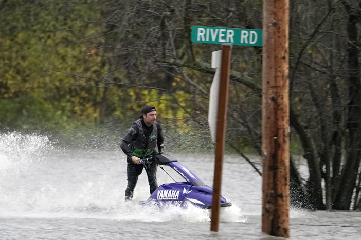 A man operates a personal watercraft along a road flooded by water from the Skagit River on Monday in Sedro-Woolley, Wash.