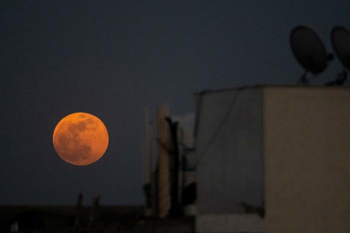 The super blood moon rises over a residential area in New Delhi during a total lunar eclipse in May.