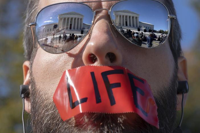 An anti-abortion activist rallies outside the Supreme Court on Nov. 1, as arguments about Texas' abortion law begin. The court has allowed the law to remain in place for now.