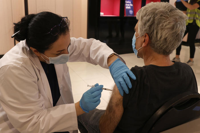 Safeway pharmacist Shahrzad Khoobyari administers a Pfizer-BioNTech COVID-19 booster shot into the arm of Norman Solomon in San Rafael, Calif., in October.