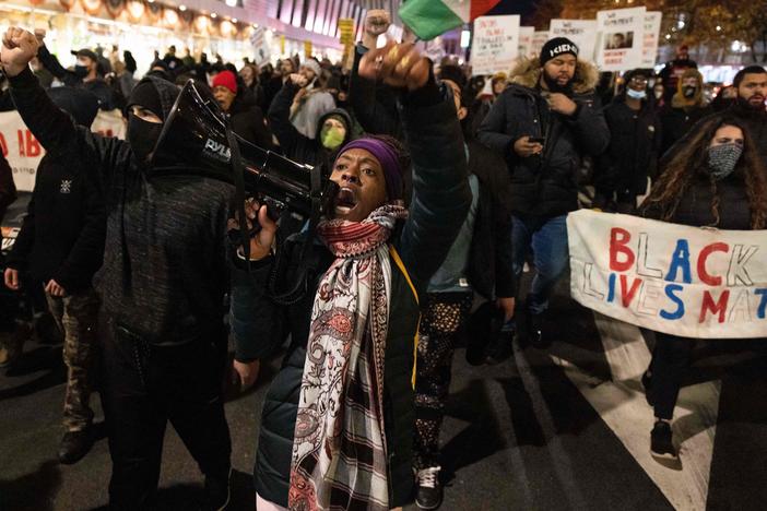 A demonstrator raises her fist while marching on the street during a protest against the Kyle Rittenhouse not-guilty verdict near the Barclays Center in New York City on Friday.
