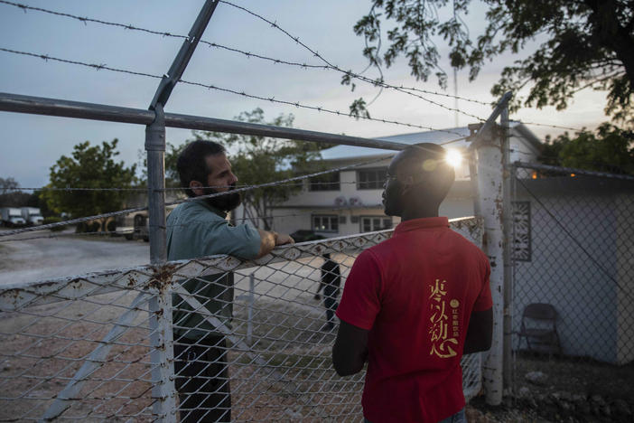 A manager at the Christian Aid Ministries headquarters, left, speaks with a worker at the door of the center in Titanyen, north of Port-au-Prince, Haiti, on Sunday.