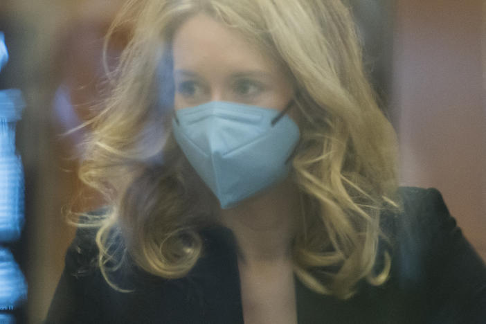 Elizabeth Holmes walks into federal court in San Jose, Calif., on Monday. Holmes is accused of duping elite financial backers, customers and patients into believing that her startup was about to revolutionize medicine.