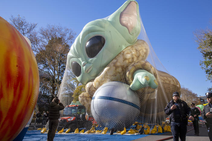 Police walk by an inflated helium balloon of Grogu, also known as Baby Yoda, from the Star Wars show The Mandalorian, on Wednesday in New York, as the balloon is readied for the Macy's Thanksgiving Day Parade on Thursday.