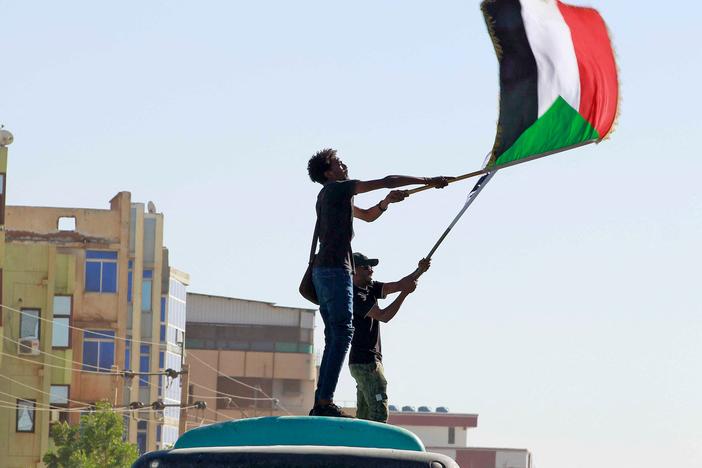 Sudanese anti-coup protesters wave the national flag during a demonstration in the Khartoum-Bahri neighbourhood of the capital, on November 25, 2021.