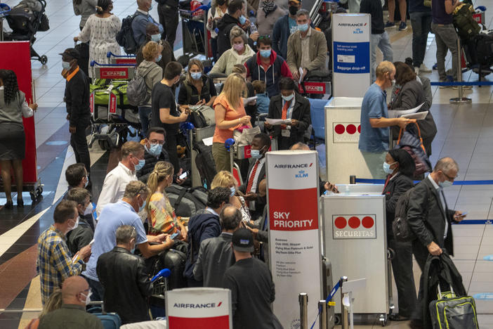 People line up to get on an Air France flight to Paris at OR Tambo's airport in Johannesburg, South Africa, on Friday as several countries announced travel bans in response to the omicron variant of the coronavirus.